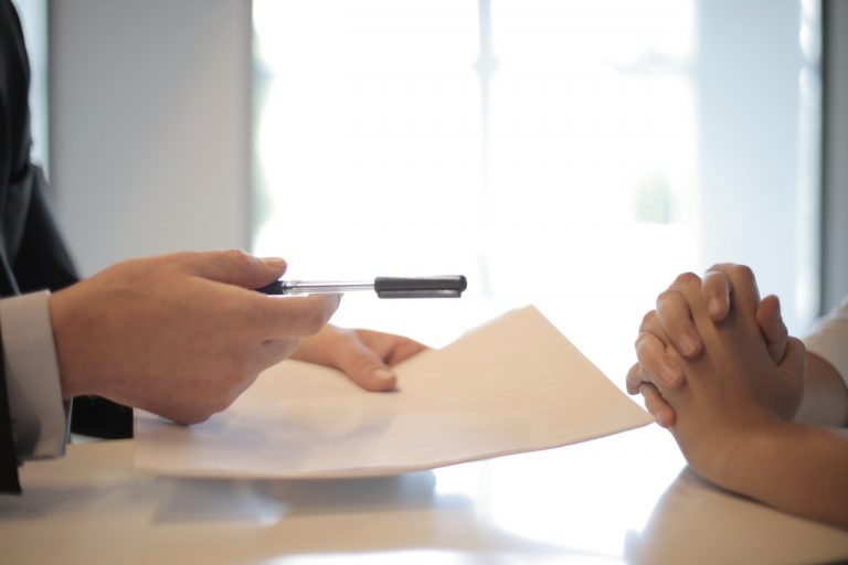 Insurance salesman giving contract to woman to sign
